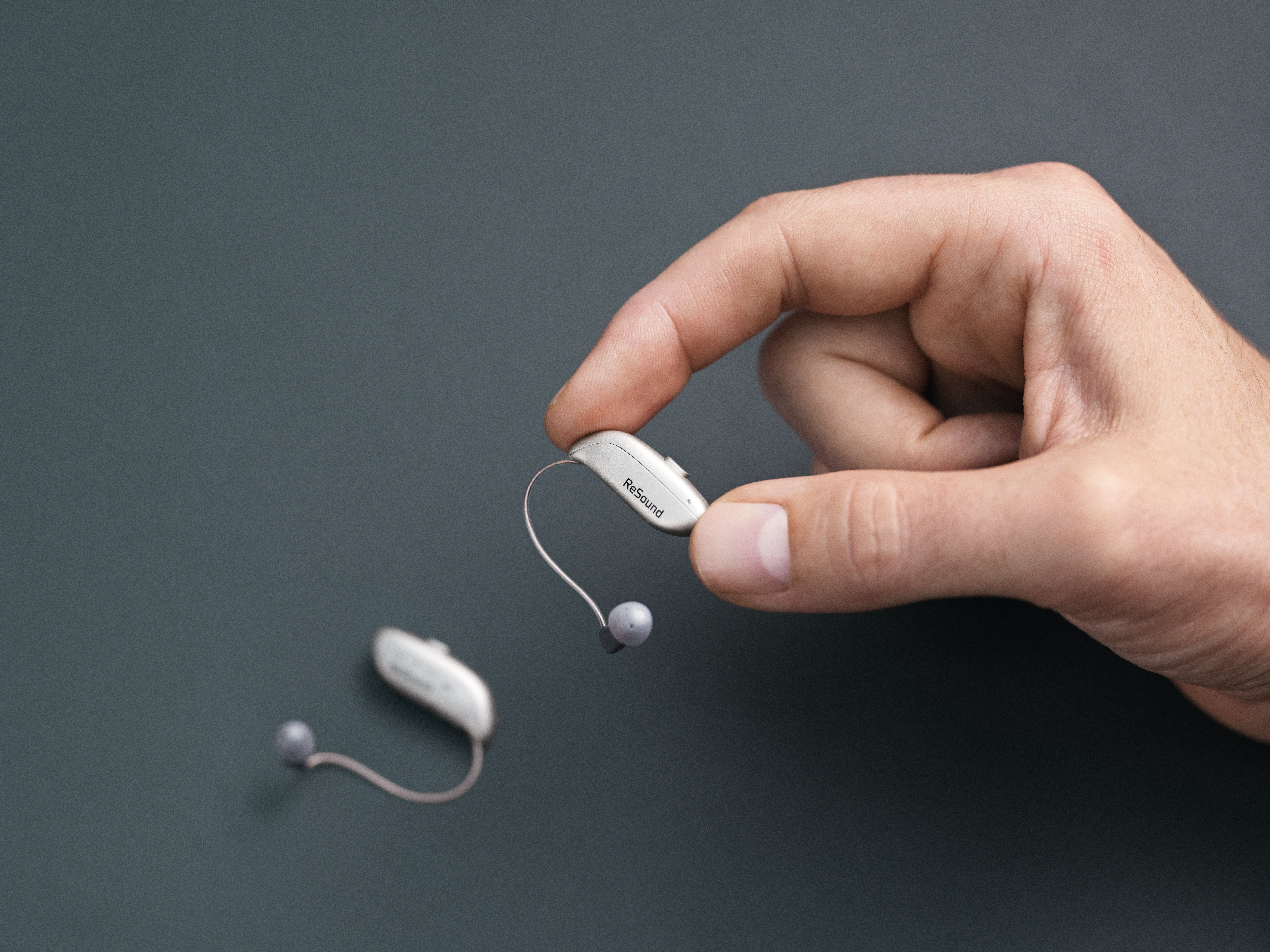 Closeup of a hand holding a hearing aid