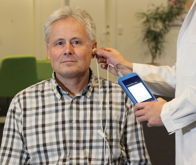doctor and patient with hearing screening device
