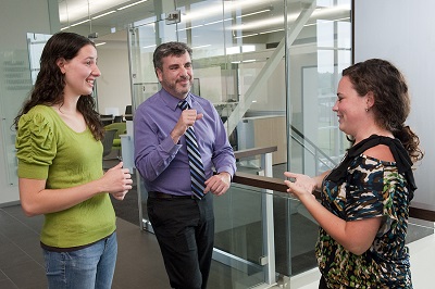 Peter Hauser chats with graduate students Gloria Wink of Rochester and Gina DeNaples of Greensboro