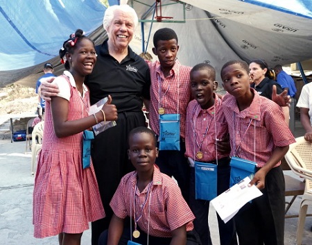 Bill Austin, founder of Starkey Hearing Foundation, shares a laugh with patients who received free hearing aids at a mission