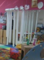 Toilet paper hanging from a curtain rod in a early childhood classroom