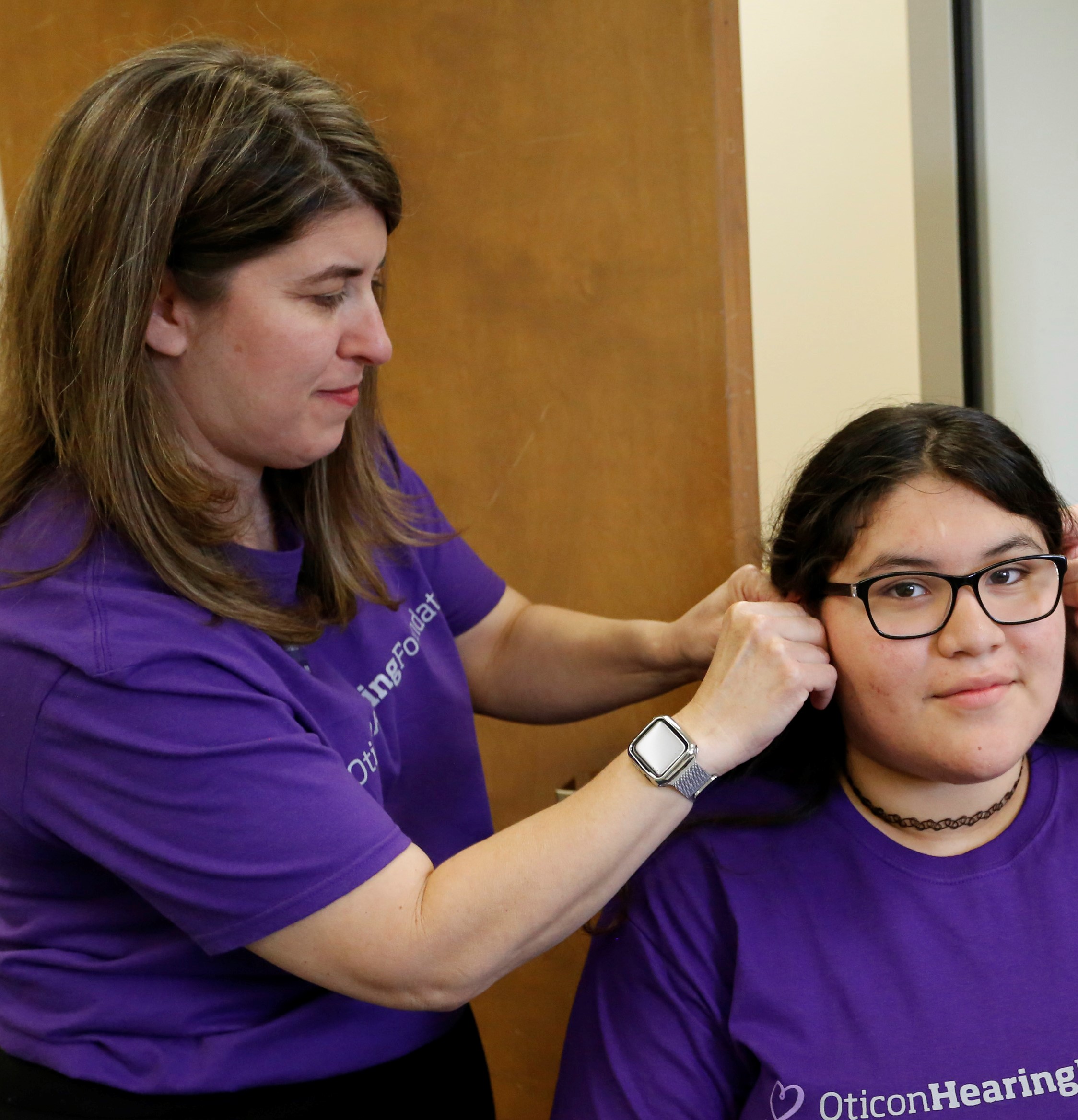 Oticon Audiologist fitting student with the new hearing aids