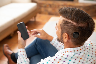 Man with sound processor and mobile phone