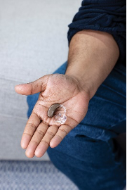 A person holding a hearing aid
