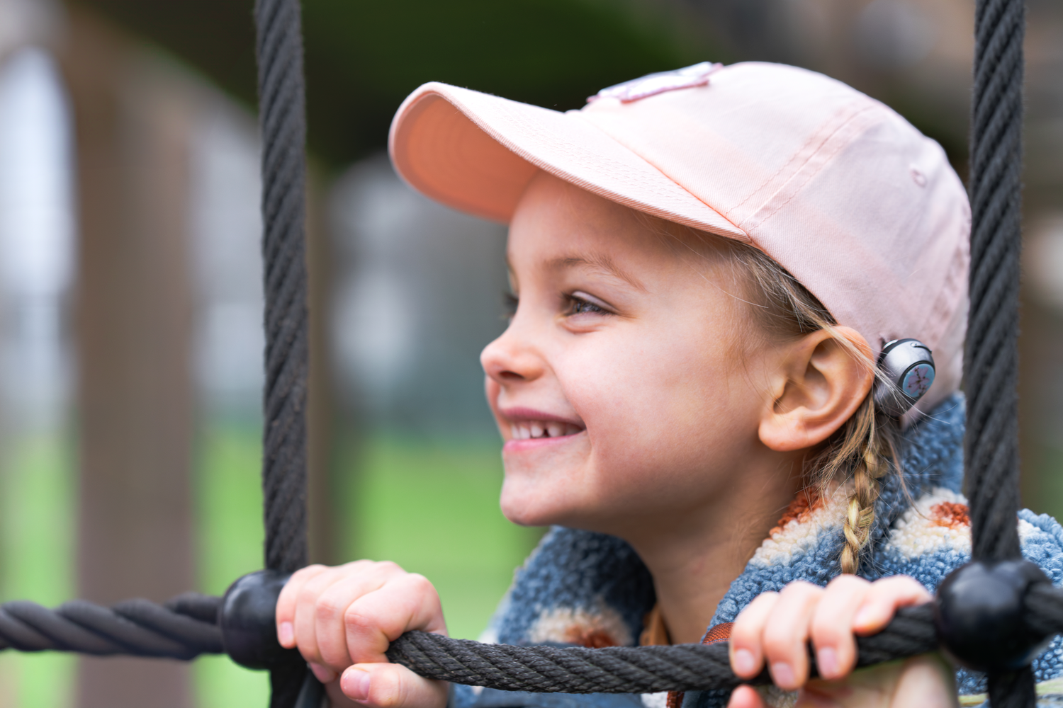 Young girl on the playground with a pink hat