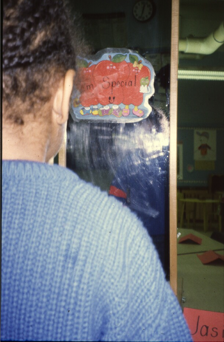Child affirmation exercise in front of mirror with an I am Special sticker on the mirror