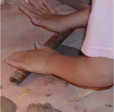 Girl using rolling pin.