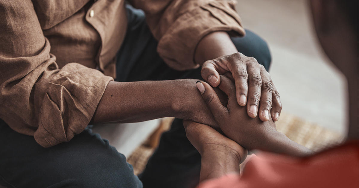 Holding hands in a comforting way.