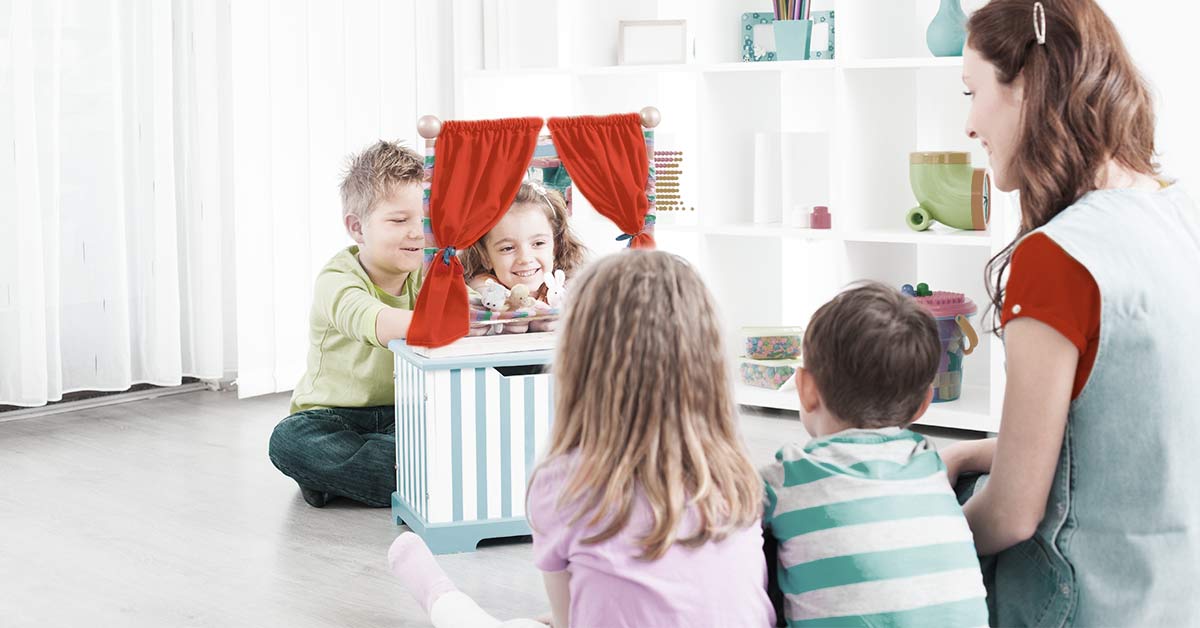 A group of children playing with finger puppets accompanied by an OT