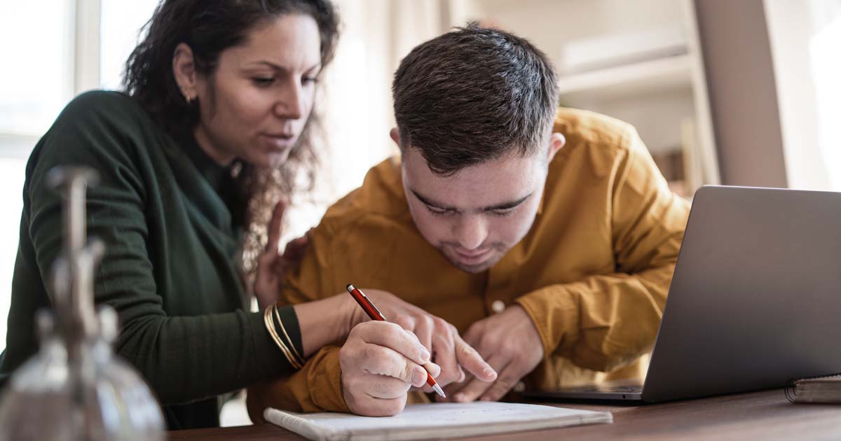 A Social worker sitting at a desk helping a client 