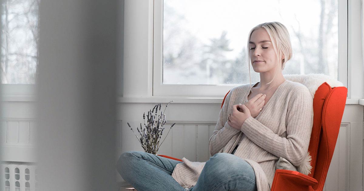 A woman sitting in a chair meditating 