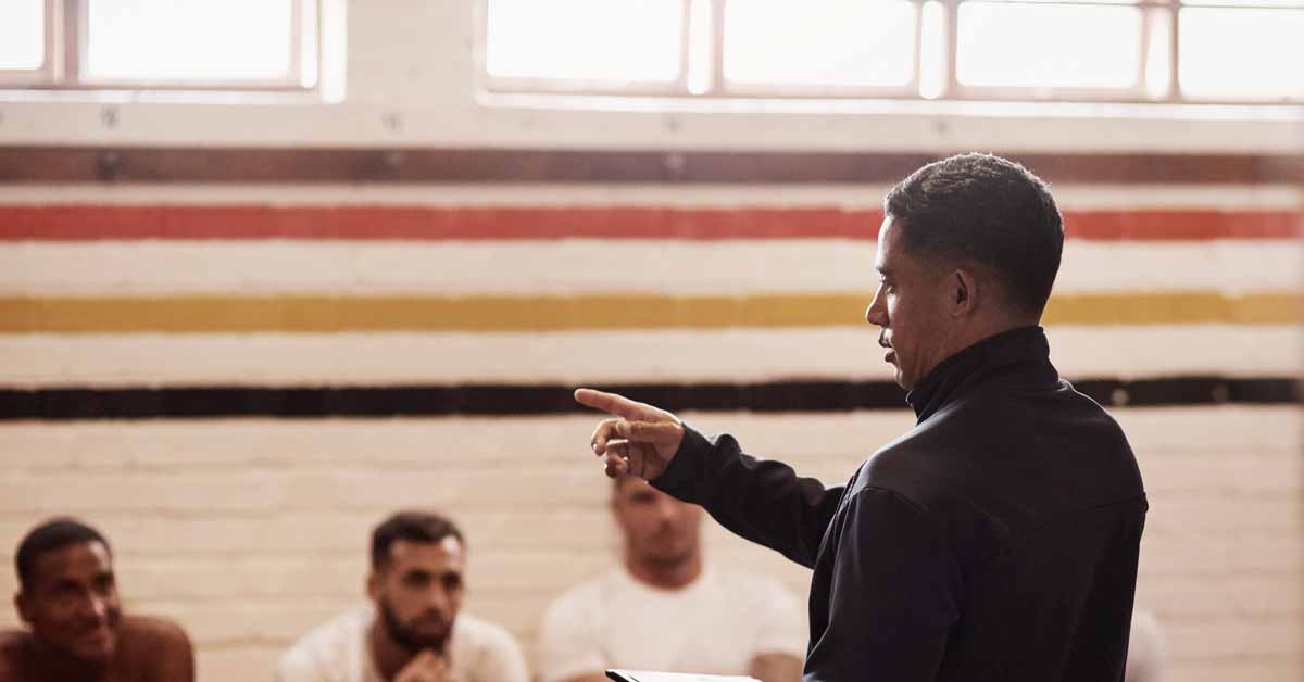 A man addressing a group of athletes