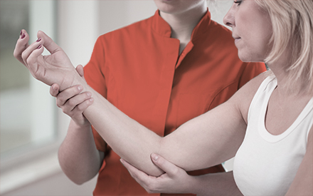 an occupational therapist holds up a person's arm and elbow