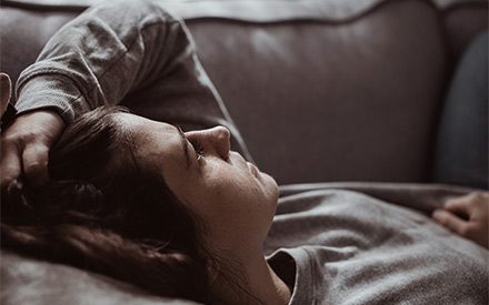 Woman lying on sofa in distress