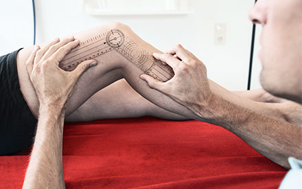 a therapist uses a tool to measure a patient's knee