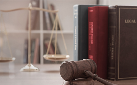 a gavel, golden scales and law books, conveying a sense of ethics