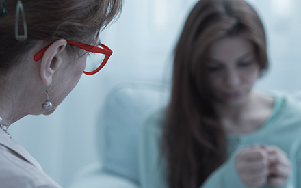 a traumatized woman speaks with a compassionate social worker